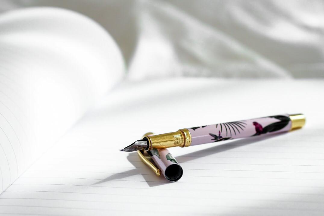 Hand writing in a notebook with a pen